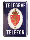 Mørkeblåt emaljeskilt med påskriften 'Telegraf Telefon'.