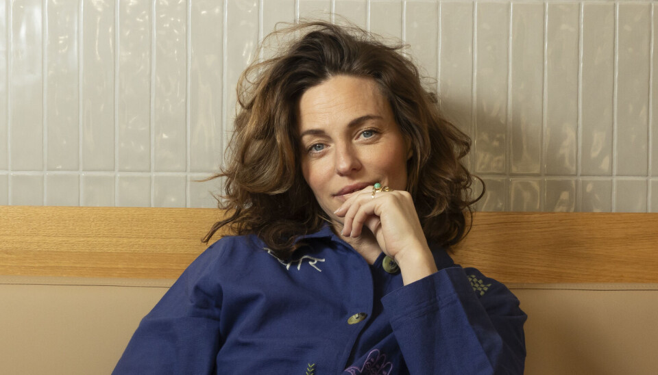 Sarah Grünewald sidder med hånden ved ansigtet.
