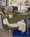 Foto af Puk Elgård, som ligger henslængt i en lænestol. Hun har en hvid kop i hånden.