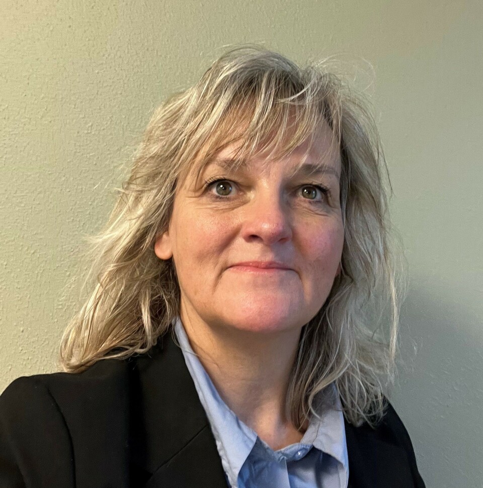 Foto af Bettina Buhl, museumsinspektør på Det Grønne Museum i blazer og blå skjorte.