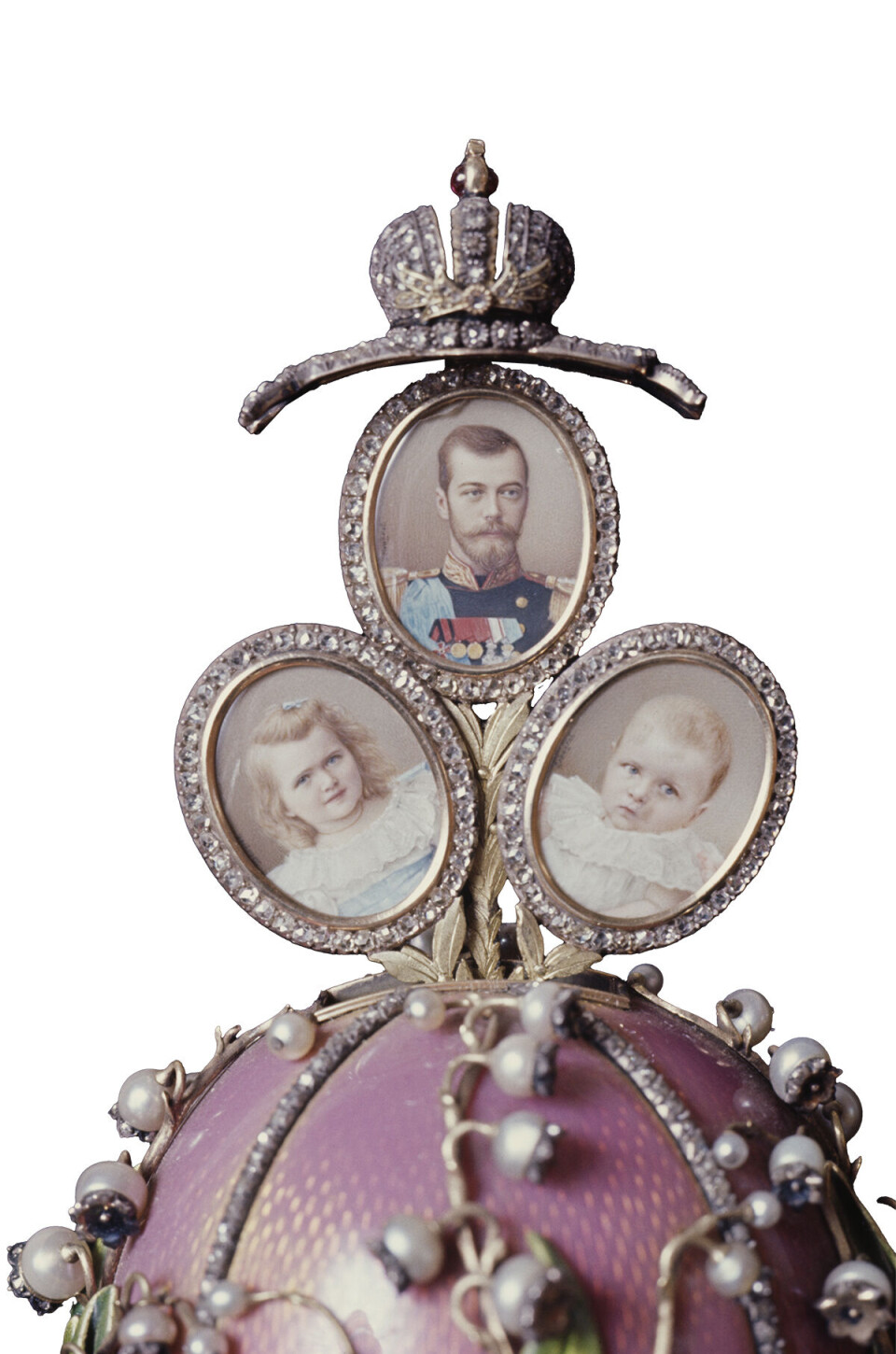 Liljekonvalægget fra 1898, som er blandt
de mest berømte.Det var inspireret
af art nouveaublomsterornamentik og frem
for alt zarinaens kærlighed til perler og liljekonvaller.
Overraskelsen er de tre miniaturebilleder af Nikolaj og kejserparrets døtre, Olga og Tatjana, som bliver synlige, når man vender kronen.