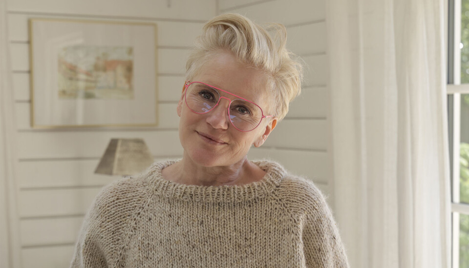 Portræt af Trine Gadeberg. Hun har en lys strikket trøje på, lyserøde briller og kort lyst hår.