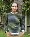 Portræt af Nola Gaardmand. Hun står udenfor, og hun har en grøn stribet langærmet trøje på, og en hvid skjorte indenunder.