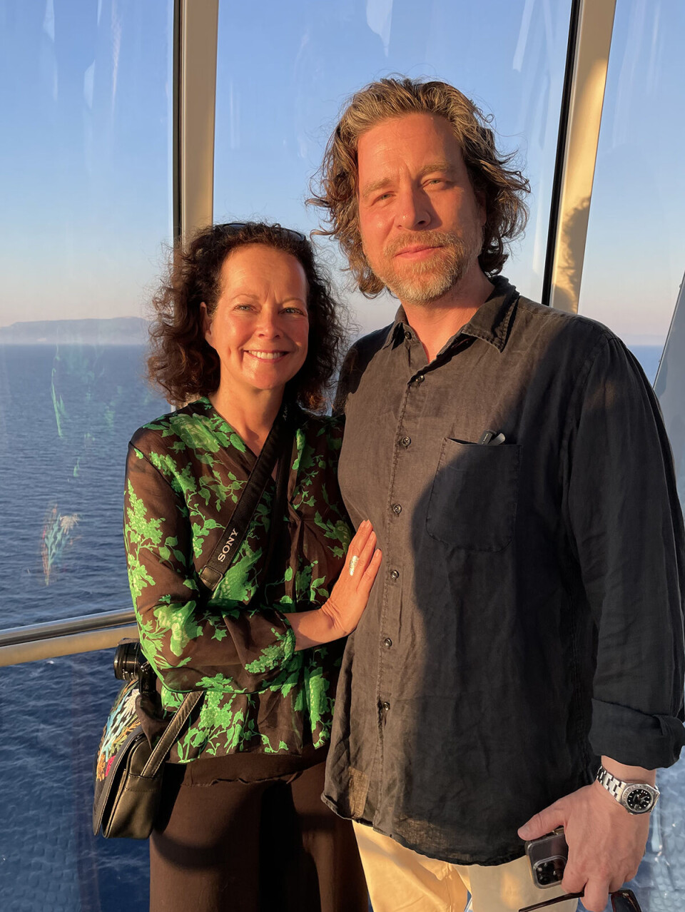 Journalist Colette van Luik og hendes mand, Elias
Modig, i en udsigtskapsel på skibet, 92 meter over havet. De kigger ind i kameraet, og i baggrunden kan man se havet.