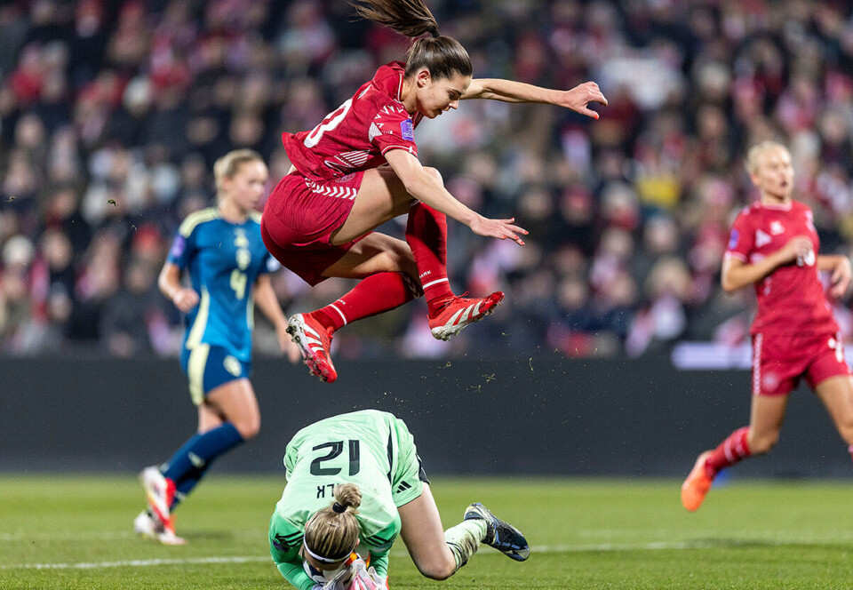 Fodboldspiller Signe Bruun ses springe henover en anden spiller under Nations League på Odense Stadion.