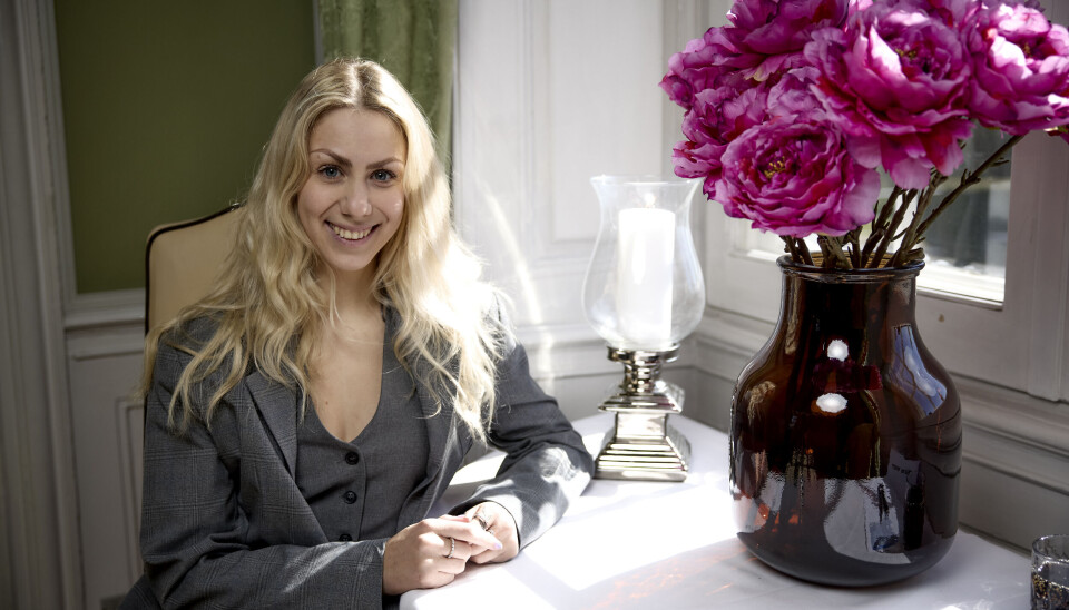 Marie Watson sidder ved bordet med flotte blomster