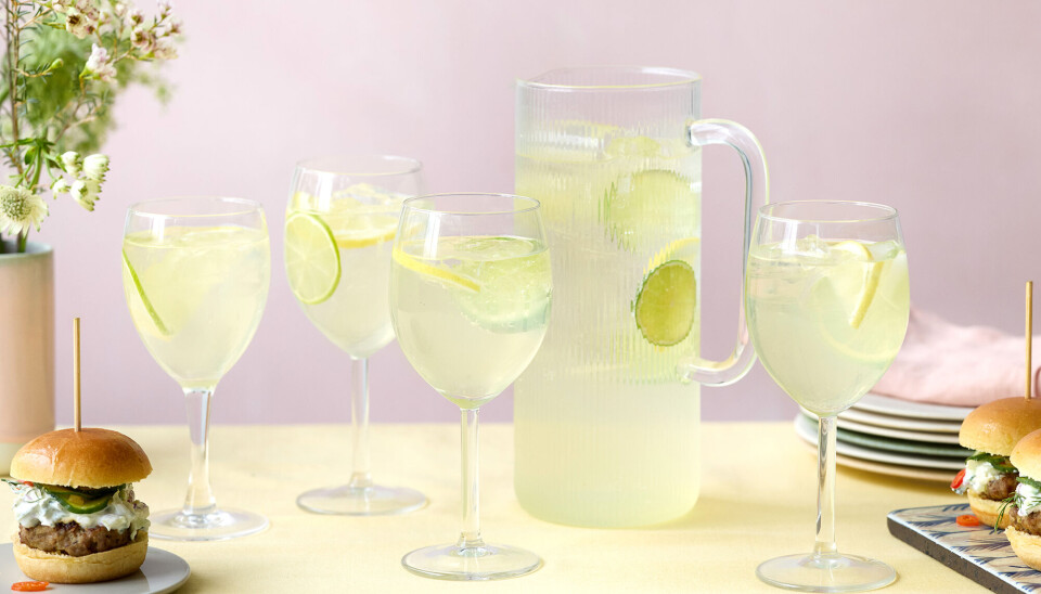 Et billede af en kande med limoncello sprizt i, og fire glas står rundt om kanden og har også limoncello sprizt i. Der er små sliders på bordet.