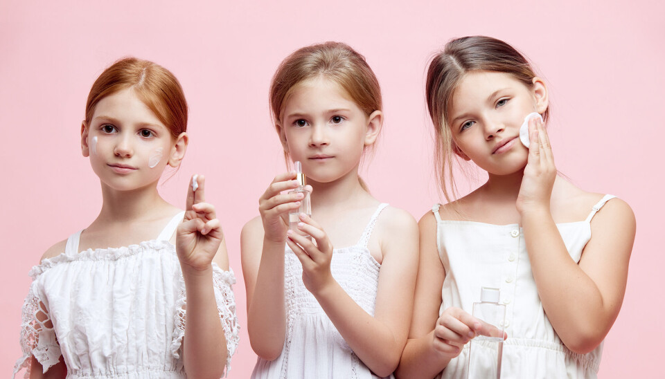 Billede af tre piger i alderen 8-10 år. Baggrunden er lyserød. Billedet skal illustrere, at børn begynder på hudpleje og make-up i en tidlig alder.