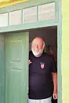 Hans Ole Matthiesen, som bor på Christiansø, hvor han bl.a. er turistguide. Her ses han i dørkarmen ved en lysegrøn dør.