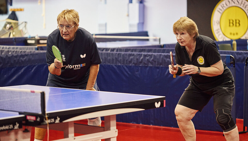 To kvinder står i dyb koncentration ved et af bordtennisbordene i Grøndalcentret, hvor de spiller.