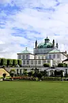 Fredensborg Slot. Billedet er taget fra haveb, og foran slottet ses buske og blomster.