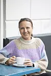 Mirja Ströhler, som er fra Tyskland, men har boet i Danmark i 13 år. Her sidder hun ved et cafébord med en kop kaffe i hånden. Hun er iført sweater i pastelfarver.