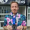Niels Mose iført farverig, blomstret habitjakke med en medalje rundt om halsen. Billedet er fra august 2024, hvor han løb sit halvmaraton nummer 500.