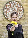 Andrea Hejlskov. Hun holder nogle gule blomster.