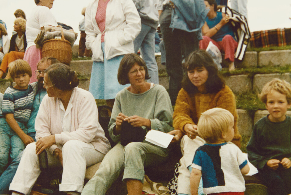 Hanne (i grønlig sweater) i 1987 på en folkemusikfestival i Roskilde. Hendes barn (med ryggen) til er klædt i håndstrik i bomuldsgarn og motiv strikket efter papirmønster.
