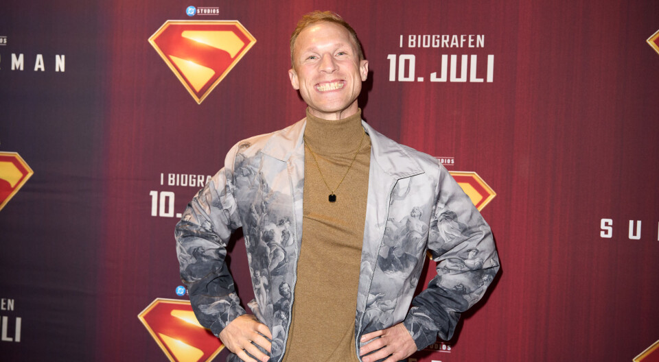Phillip May smiler på den røde løber til premieren på Superman