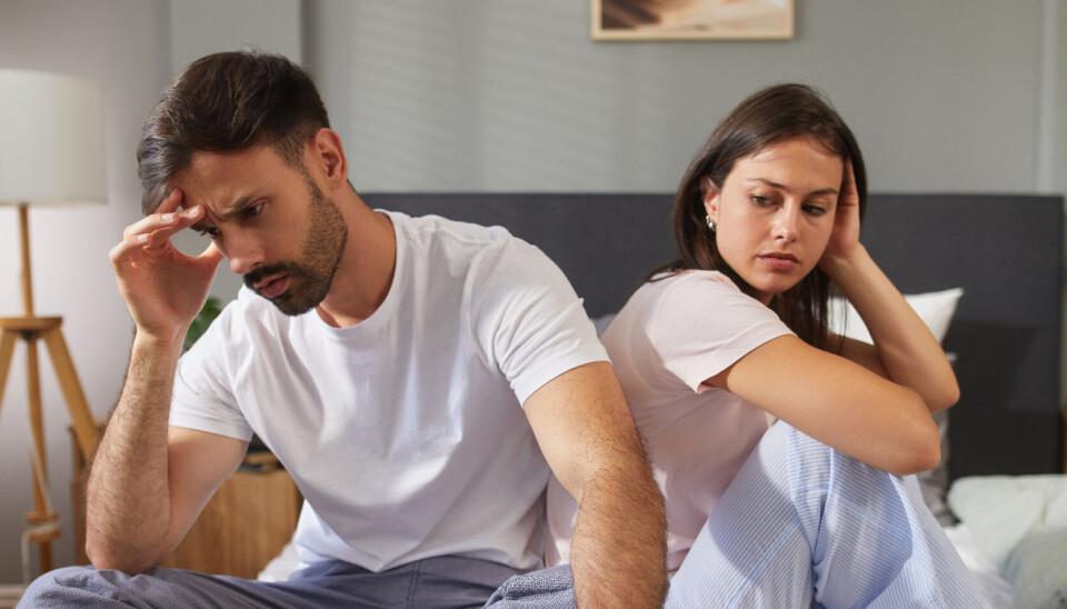 Mand og kvinde sidder i en seng.