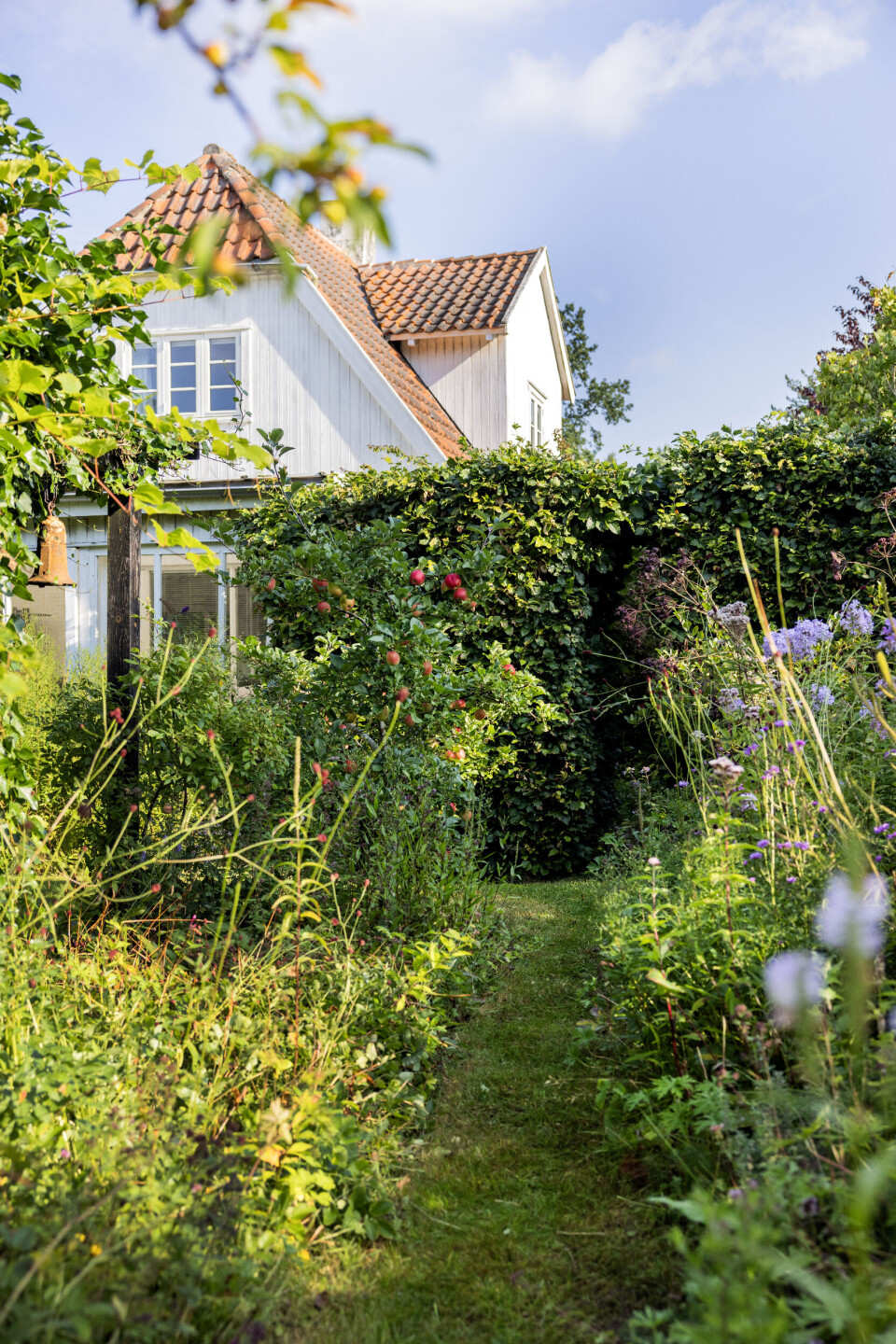 Der er spændende at tage på rundfart i Anne Gine og Leifs have, for den er fyldt med stier og skønne kroge, så der er hele tiden noget nyt at kigge på. Bemærk den sjove klokke øverst til venstre, som oprindeligt stammer fra en gammel wc-cisterne.
