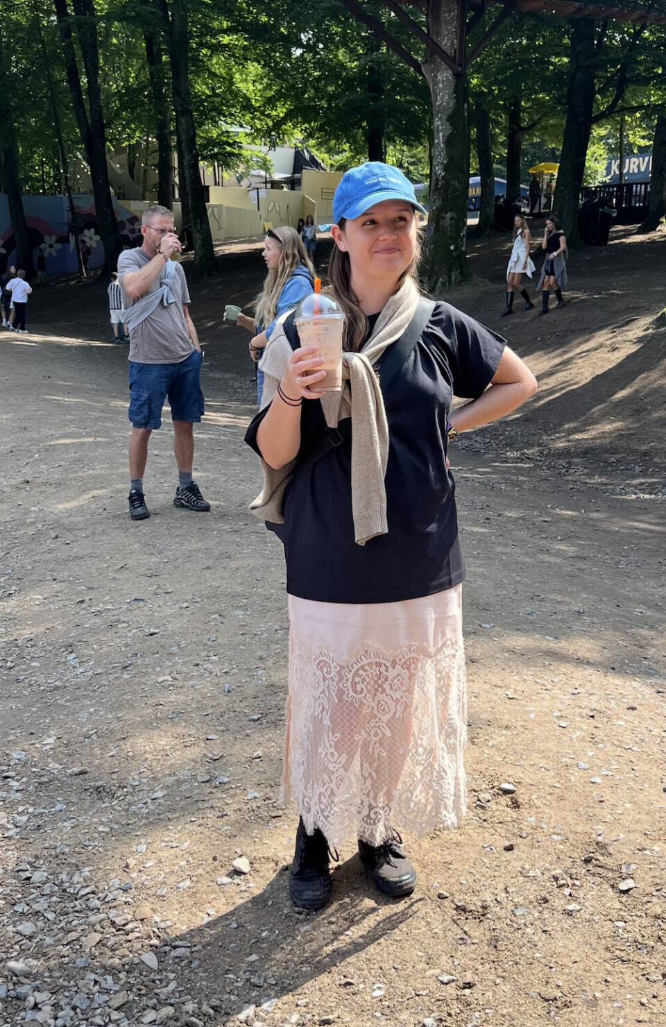 Kvinde i hvid blondenederdel og oversized short tshirt med milkshake i hånden til Smukfest