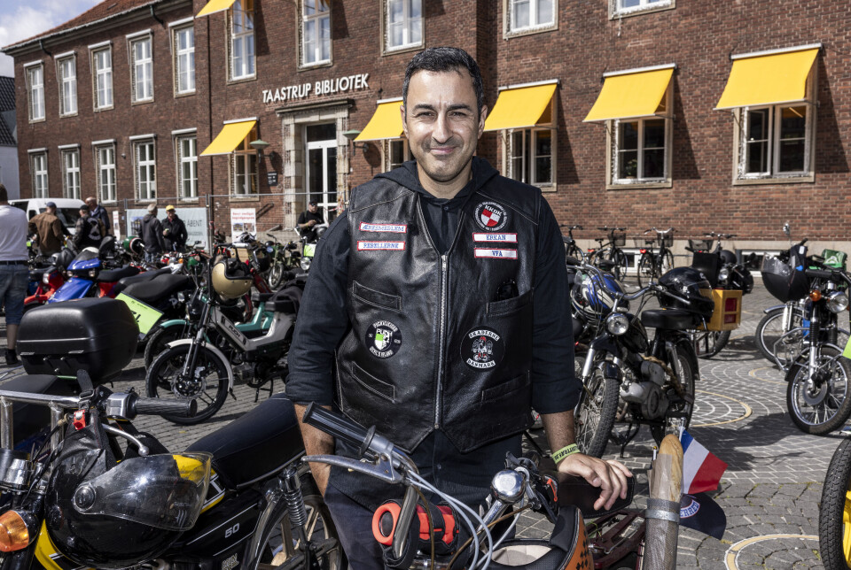 Erkan står med sin knallert og smiler.