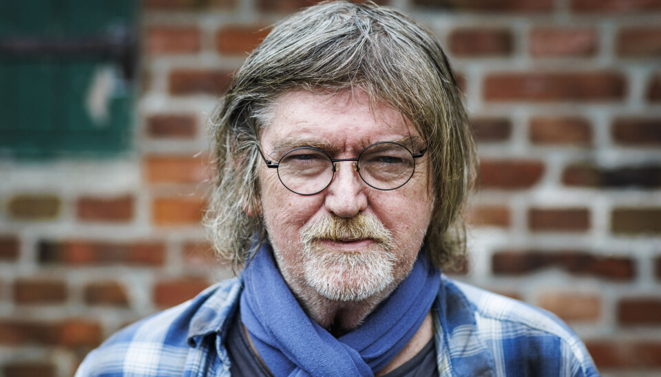 Johnny Madsen iført en ternet blå skjorte og et blåt halstørklæde.