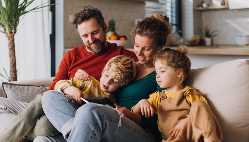 Familie sidder i sofaen.