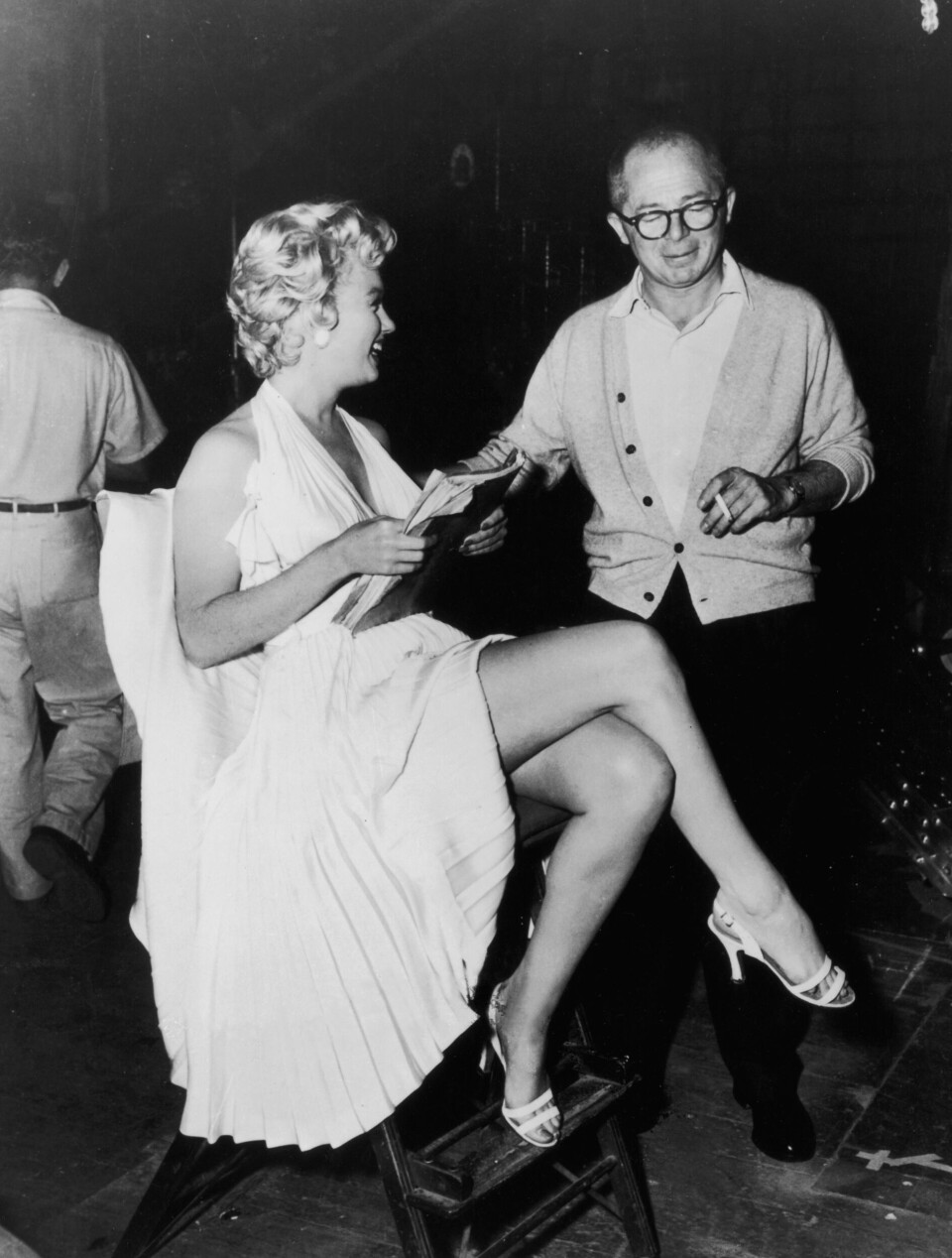 Skuespiller Marilyn Monroe (1926 - 1962) holder et manuskript, mens hun sidder ved siden af instruktør Billy Wilder