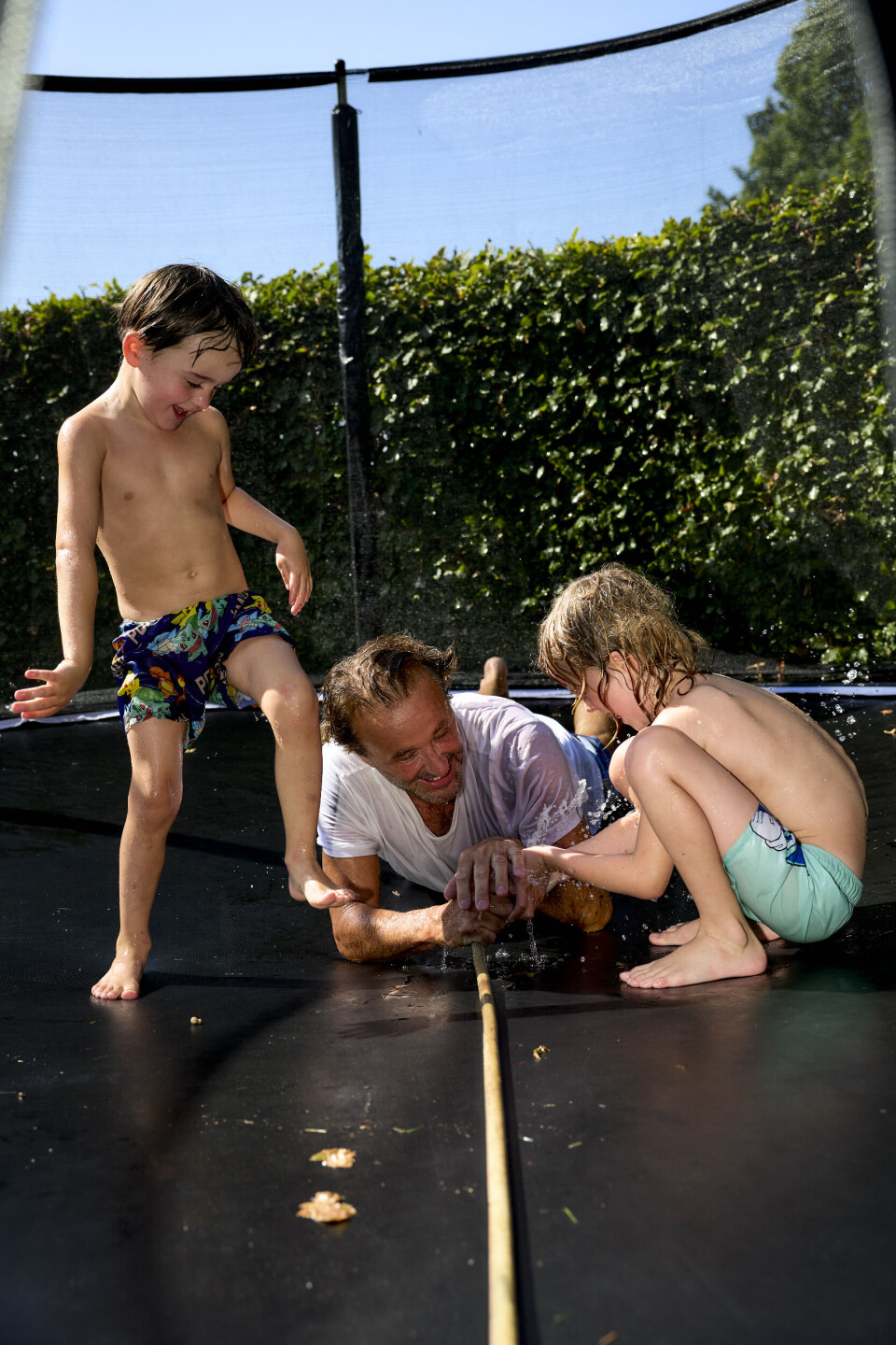 Lucas, Noah og Dennis leger med vand på trampolinen