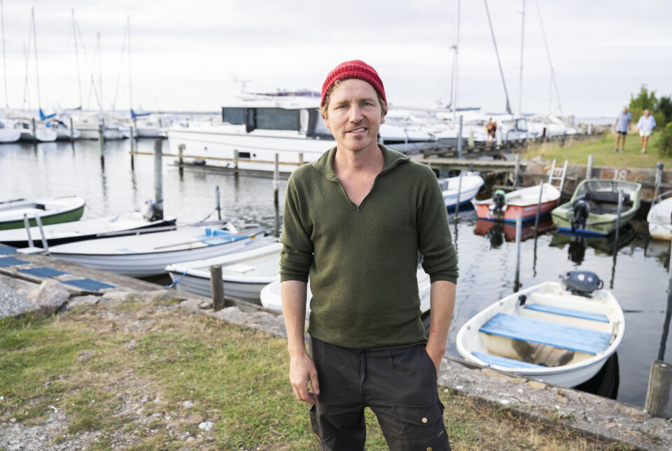 Frank 'Bonderøven' står ved havnen med en rød hue på.
