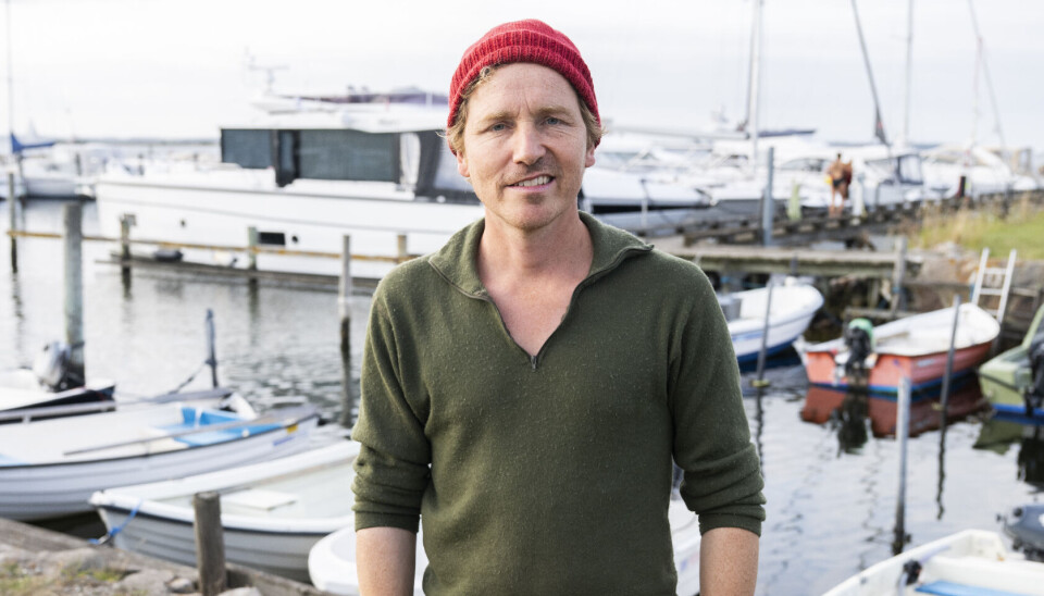 Frank 'Bonderøven' står ved havnen med en rød hue på.