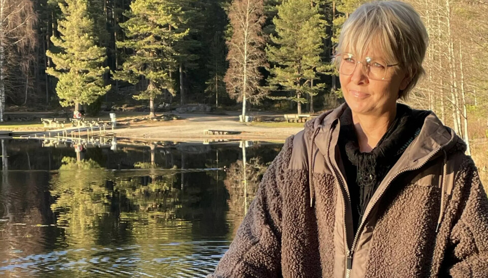 Merete står ved en skovsø i naturen.