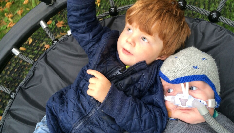 Asker på 3 år og Knud på under et år ligger sammen på en trampolin. Knud er syg og har en slange i næsen