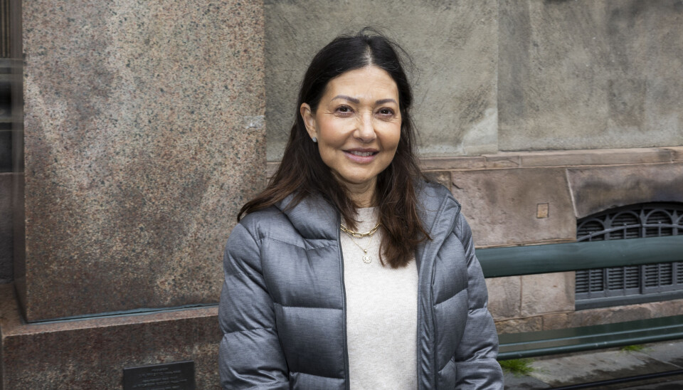 Grevinde Alexandra står foran en mur med en grå dunjakke