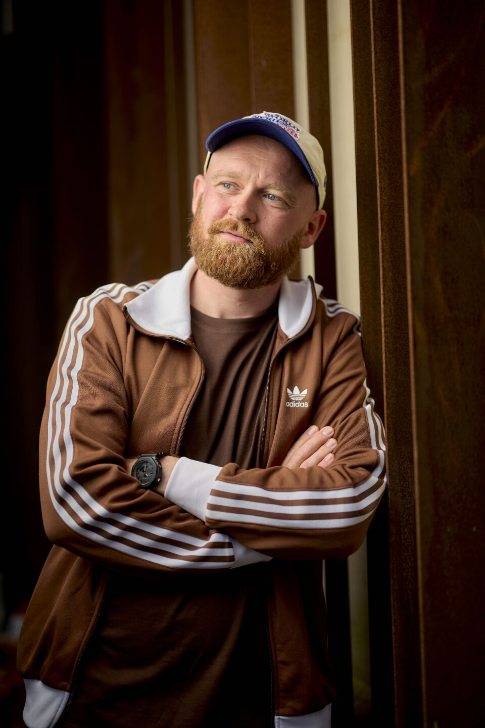 Portrætbillede af Mark Le Fevre iklædt en adidastrøje og kasket, hvor han kigger væk fra kameralinsen.