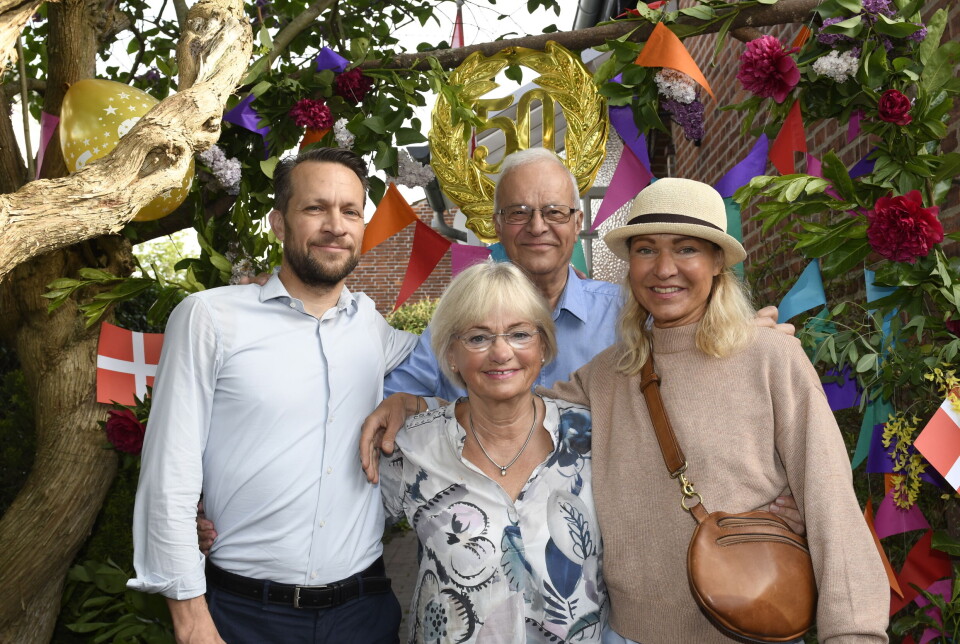 Pia Kjærsgaard i selskab med familie til sit guldbryllup. Der er pyntet op i træerne med flag og de smiler ind i kameraet.