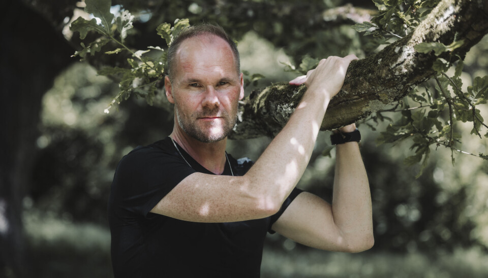 Portrætfoto af Danni, hvor han står foran et træ og holder i en gren.