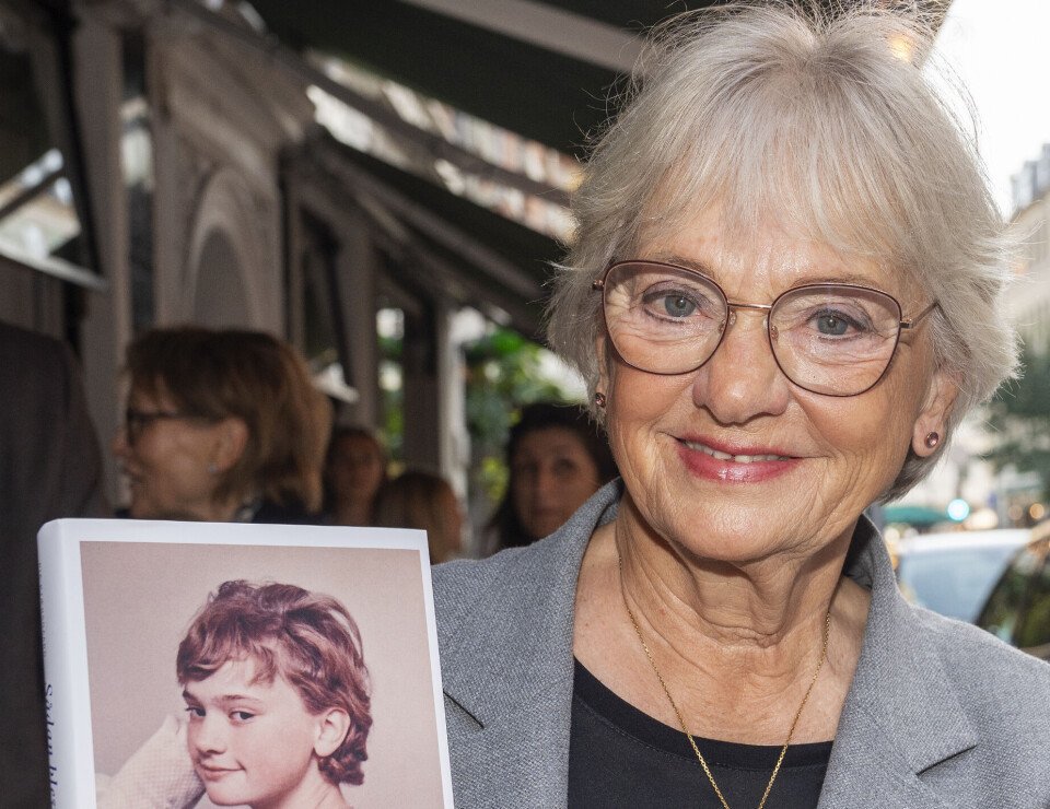 Pia Kjærsgaard står med sin bog.