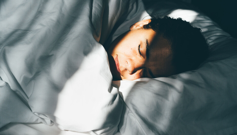 Kvinde ligger og sover med hovedet på en hovedpude.