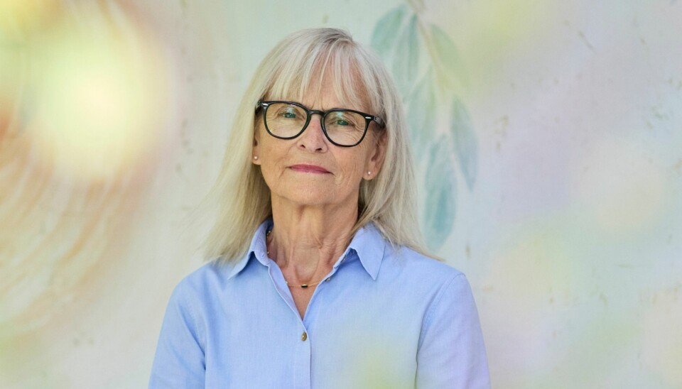 Rita Lohmann. Hun har en lyseblå skjorte på, sorte briller, og lang, lyst hår.
