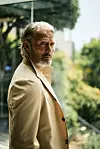 Mads Mikkelsen kigger i kameraet iført beige jakke