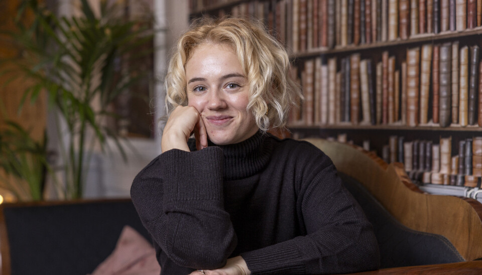 Portræt af Laura, hvor hun hviler hovedet på sin hånd og smiler ind i kameraet.