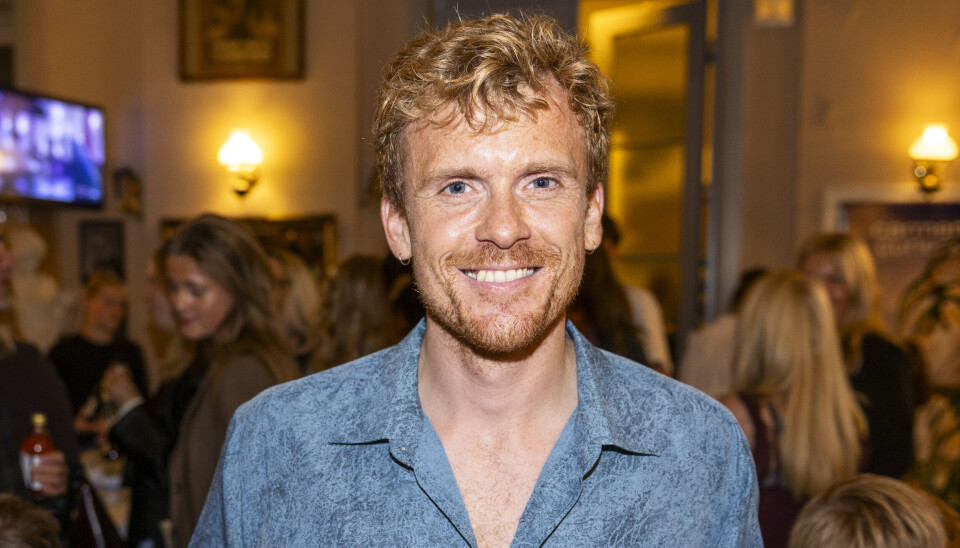 Morten Hee Andersen står med to bøtter med popcorn. Èn i hver hånd og smiler ind i kameraet.
