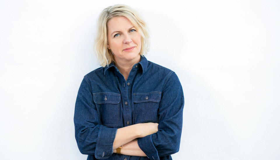 Journalist Dorte Mosbæk kigger i kameraet iført denimskjorte.