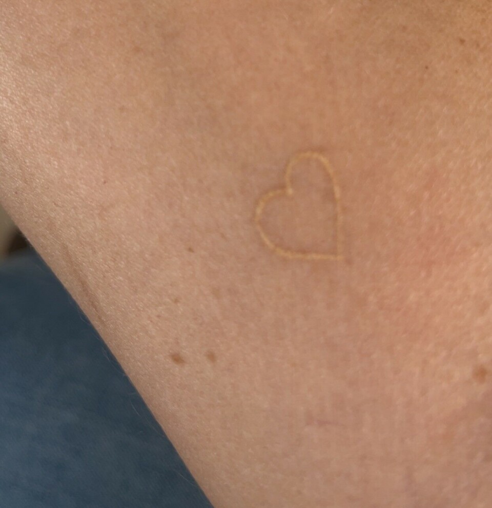 Hvid tatovering af et hjerte.