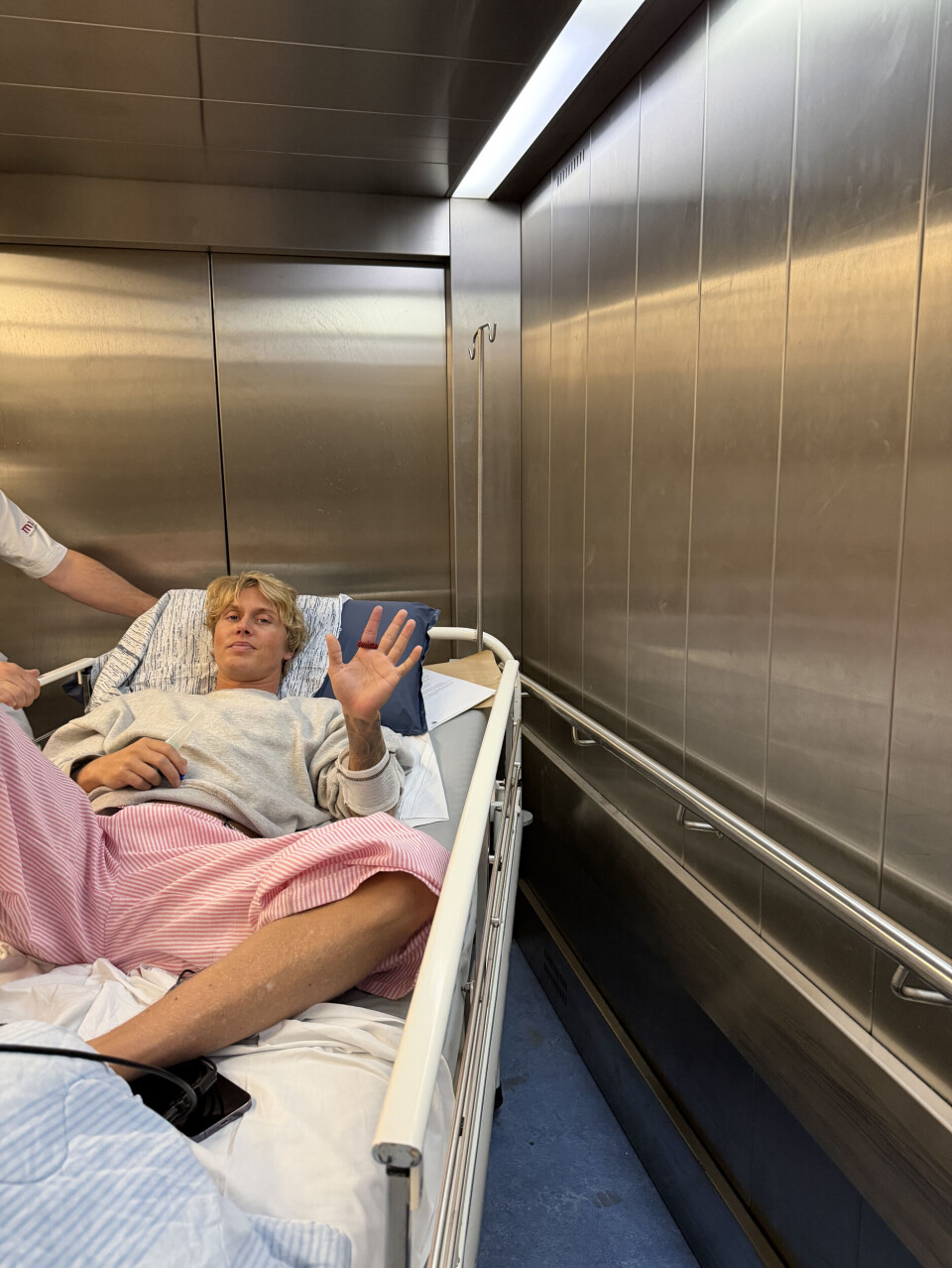 Nicolaj vinker til kammeraet fra sin hospitalsseng.