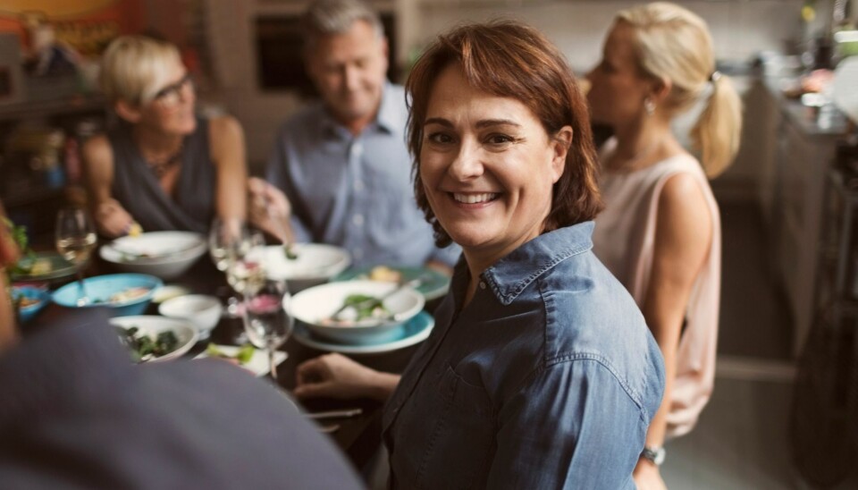 En kvinde sidder rundt om et bord.
