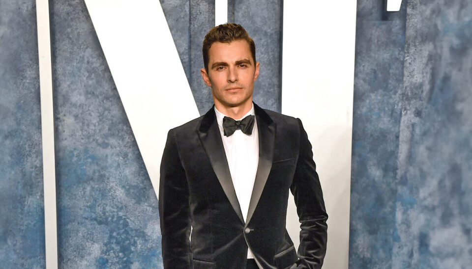 Dave Franco i en sort smoking med sort butterfly.