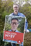 Finn viser sin valgplakat frem.