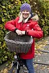 Mette ved sin cykel iklædt en rød jakke.