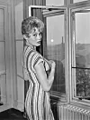French actress Brigitte Bardot standing at the window of her room at the Savoy Hotel, London, October 27th 1956.